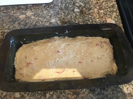 A loaf of pepperoni cheese bread in a pan.