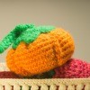 A crocheted pumpkin in a bowl.