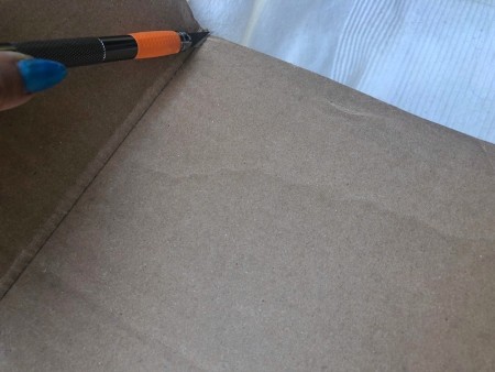 Cardboard Window Monster - cutting a flat piece from the cardboard box