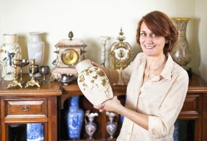 A woman holding an antique vase.