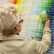 A woman looking at different color paint swatches.