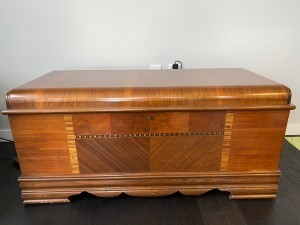 A hope chest with an inlaid wood pattern.