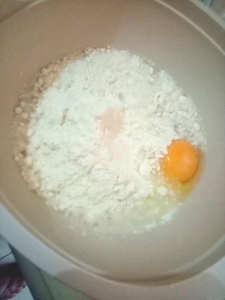Mixing up pancake batter with egg.