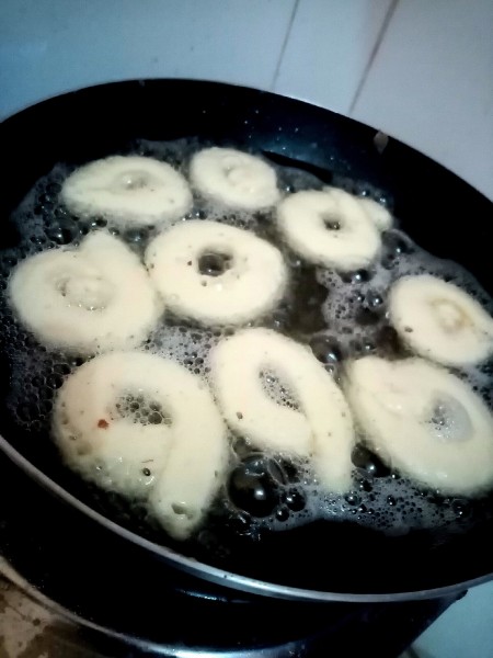 Frying rings of batter in hot oil.