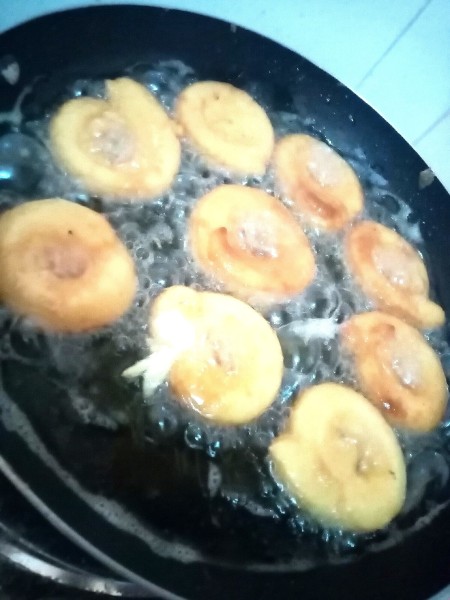 Flipping the doughnuts while cooking.