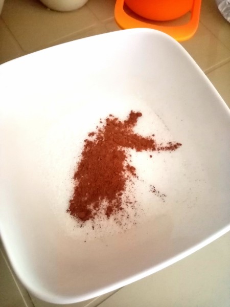 Adding cinnamon to a dish.