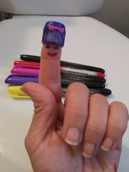 Lego Minifig Toothpaste Cap - bow cap on finger with face drawn on finger