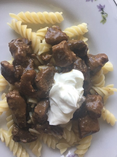 Sauerbraten over noodles with a dollop of sour cream.