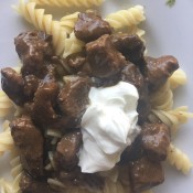 Sauerbraten over noodles with a dollop of sour cream.
