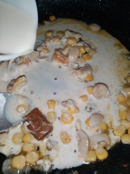 Adding milk to the pan.