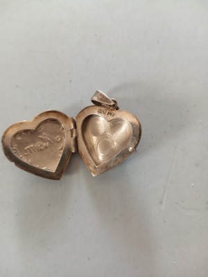 A metal locket with a marking inside.