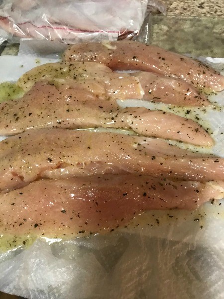 The chicken breasts coated with the butter herb mixture.