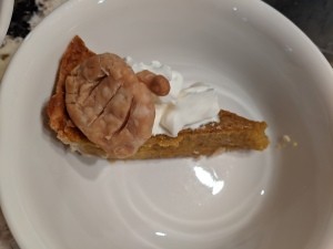 A slice of pumpkin pie with whipped cream.