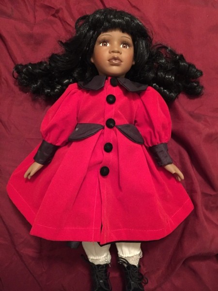 A porcelain doll in a red dress.