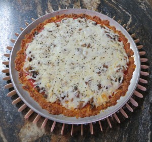 A pizza cooling on a trivet.