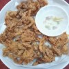 A finished plate of mushroom chicharon served with spicy vinegar.