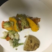 A plate of salmon with avocado mango salsa.