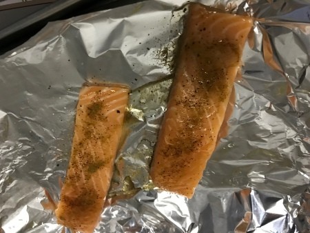 Two salmon filets on aluminum foil.