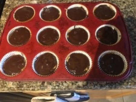 A muffin tray with filled peanut butter brownie cups.