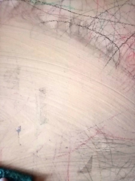 A swath of clean area on a scribbled-on wall.