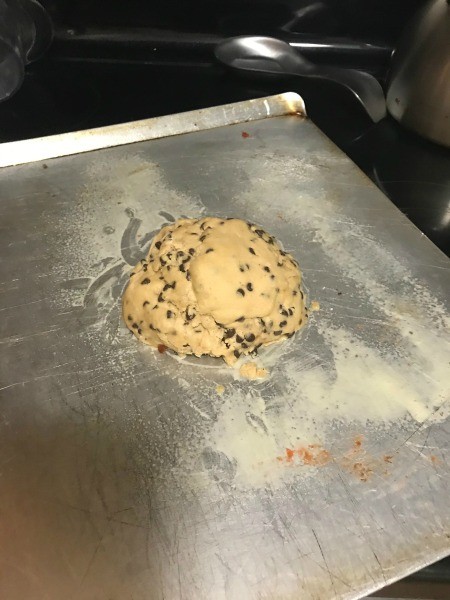 A large ball of cookie dough on a baking sheet.