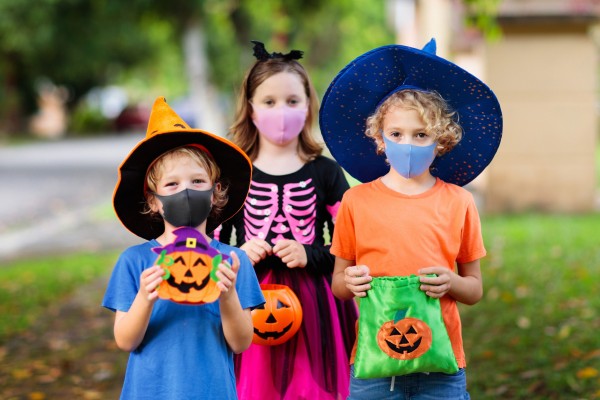 Three trick-or-treaters in COVID masks.