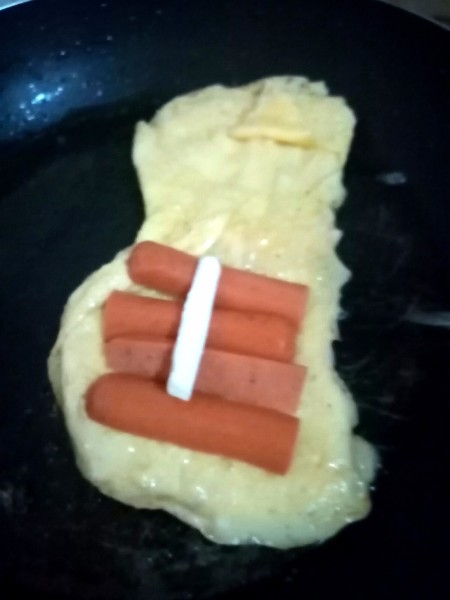 Adding sausage and cheese to the pan.