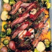 A creepy zombie meatloaf with roasted vegetables around it.