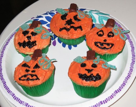 Cupcakes decorated to resemble jack-o'-lanterns.