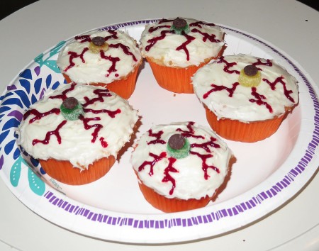 Cupcakes decorated to resemble bloodshot eyes.
