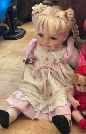 A doll with blonde hair and a pink and white dress.