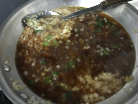 Adding broth to the onions, making a French onion sauce.