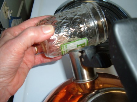 Holding the glass jar with a label over the steam from a kettle.