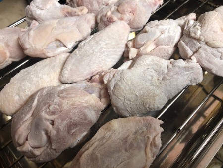 A tray of uncooked chicken wings.