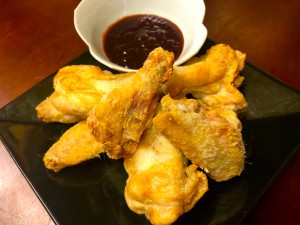 A plate of crispy bat wings with dipping sauce.