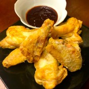 A plate of crispy bat wings with dipping sauce.
