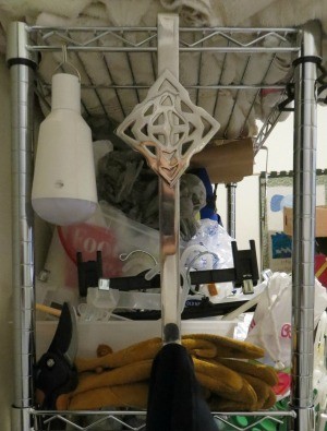 A wreath hanger holding up a cleaning towel.