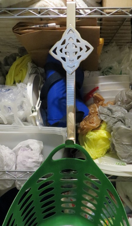 A wreath hanger holding up a basket in the pantry.