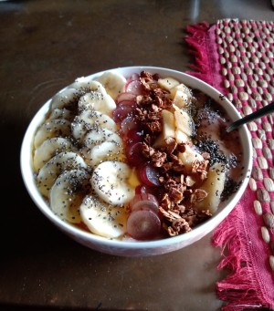 A healthy acai bowl with lots of fruits and toppings.