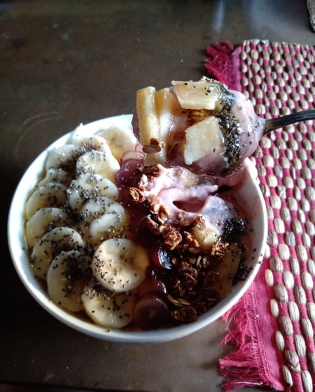 A healthy acai bowl with lots of fruits and toppings.
