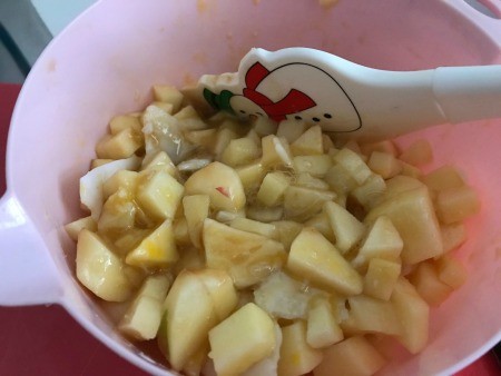 Mixing the apples in the spice blend.