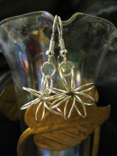 Starburst Earrings - earrings hanging on a glass vase