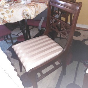 A wooden dining chair with a striped seat.