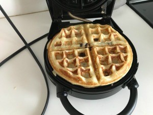 A cooked waffle in the waffle maker.