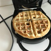 A cooked waffle in the waffle maker.