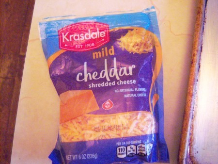 A package of shredded cheddar cheese.