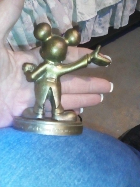 A brass Mickey Mouse figurine from the back.