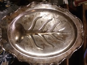 A silver tray with a leaf pattern in the center.