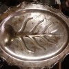 A silver tray with a leaf pattern in the center.