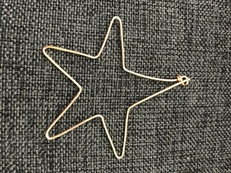 A bent wire ornament in the shape of a star.